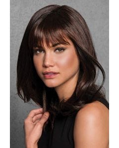 Woman in a past the shoulders layered dark auburn wig with arched bangs