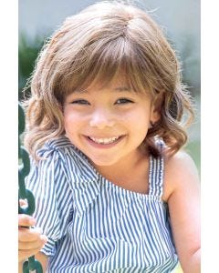 Little girl in a shoulder length light brown curly children's lace front wig
