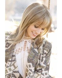 Woman in long blonde layered wig with bangs