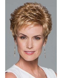 Woman in a strawberry blonde pixie wig with curled spiky layering on top and fringe bangs