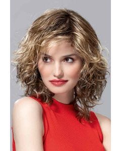 Woman in a shoulder length curly platinum blonde wig with side bangs