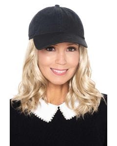 Woman in black baseball cap with blonde curly long hair attached