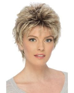 Woman in a long teased dark blonde pixie wig with fringe bangs