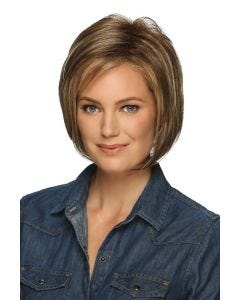 Woman in a chin length golden brown layered angled bob wig