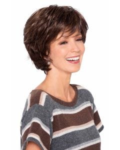 Woman in brown medium length layered wig with bangs and waves
