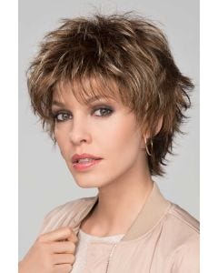 Woman in a long shaggy medium brown pixie wig with wispy bangs