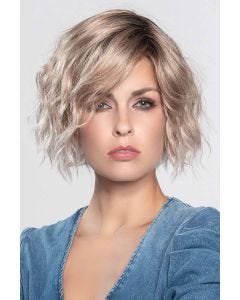 Woman in a chin length curly platinum blonde lace front wig
