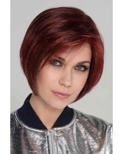 Woman in an angled dark red chin length bob wig with face framing layers