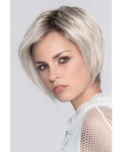 Woman in a chin length platinum blonde angled bob wig