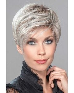 Woman in a platinum blonde pixie wig with longer layers on the top and sides
