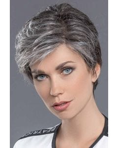 Woman in a tousled salt and pepper layered human hair pixie wig