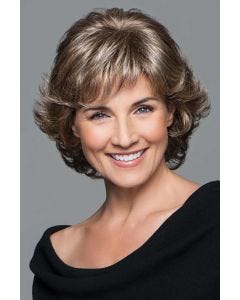 Woman in a short dark blonde curly wig with textured bangs