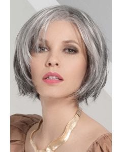 Woman in a chin length salt and pepper layered bob wig