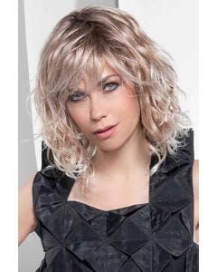 Woman in a shoulder length curly light blonde wig with side bangs