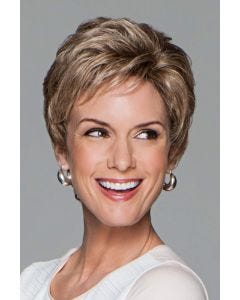 Woman in light brown pixie wig with longer, wavy layers on top with short wispy bangs