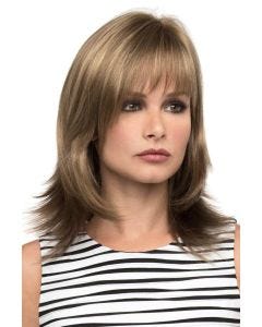 Woman in a shoulder length dark ash blonde wig with feathered layers and arched bangs