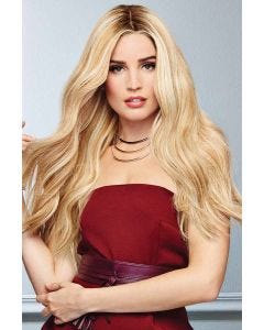 Woman in an extra long warm blonde wavy wig with dark roots