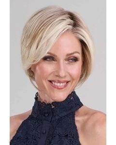 Woman in a light blonde angled chin length bob wig with dark roots