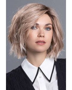 Woman in a past the chin tousled light brown razored bob wig