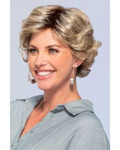 Woman in short curly blonde wig with bangs and layers for an older woman