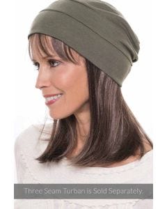 Woman in a long straight halo wig with bangs under an olive snood hat