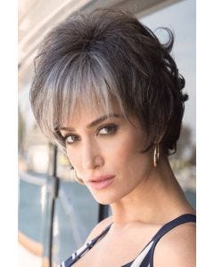 Woman in short grey curly wig with bangs