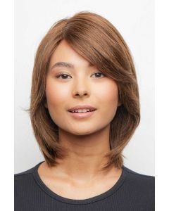 Woman in a shoulder length warm brown rounded bob wig with side bangs