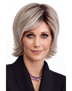 Woman in a shoulder length razor cut light blonde wig with fringe bangs