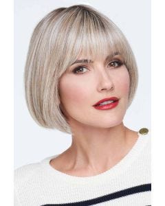 Woman in a past the chin ash blonde stacked lace front bob wig with fringe bangs