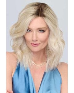 Woman in a past the shoulders platinum blonde lace front wavy wig