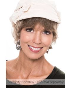 Woman in a short wavy ash blonde halo wig under a cream newsboy hat