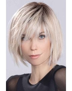 Woman in a  past the chin choppy platinum lace front wig with long bangs