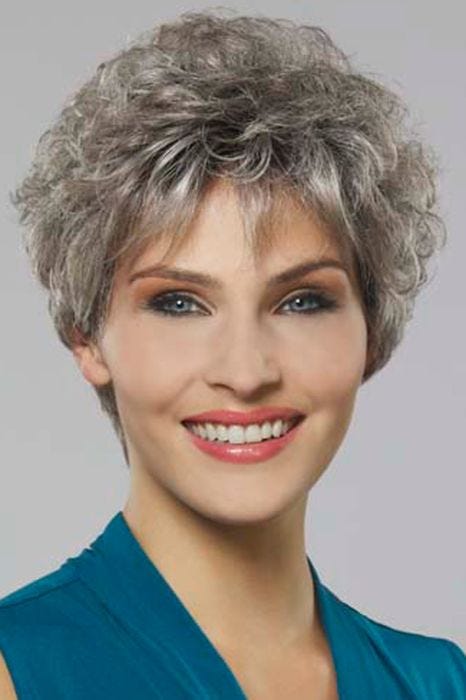 Woman in a grey curly pixie wig with textured bangs
