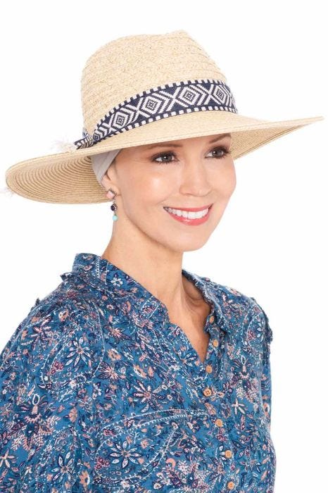 Woman in straw summer fedora hat with ikat band accent with headband underneath for cancer patients