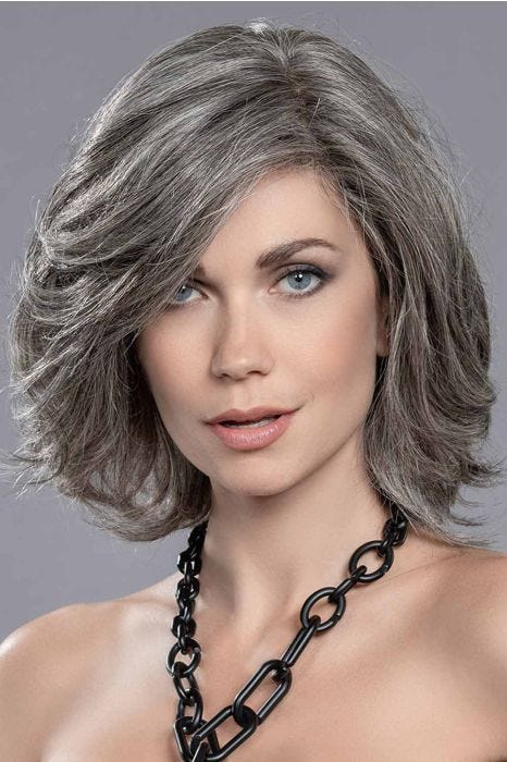 Woman in a shoulder length grey layered human hair bob wig