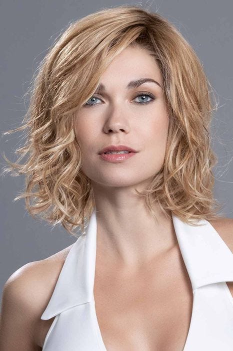 Woman in a shoulder length curly ginger blonde lace front bob wig