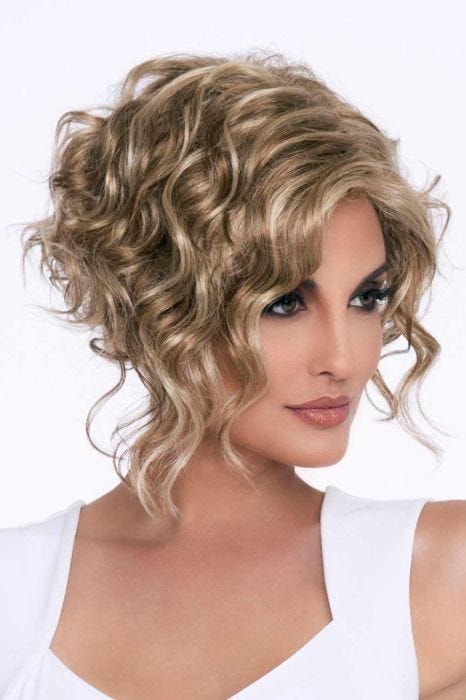 Woman in an almost shoulder length angled light brown curly wig
