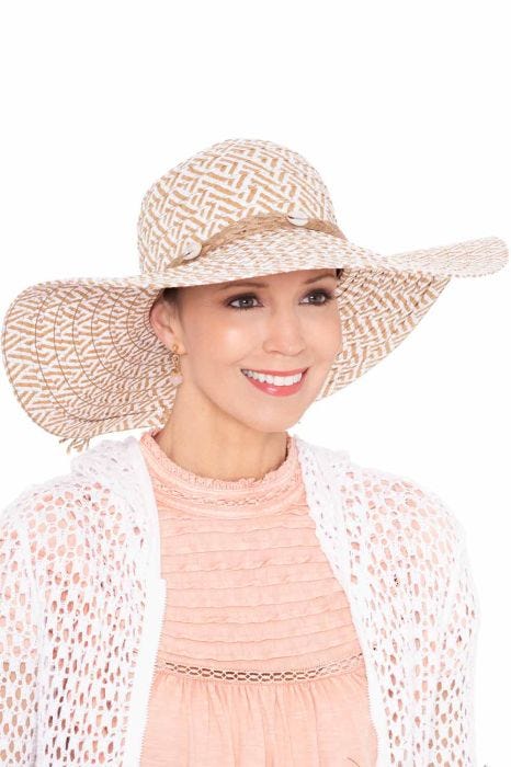 Woman in extra wide brimmed floppy woven beach or sun hat with shell accents