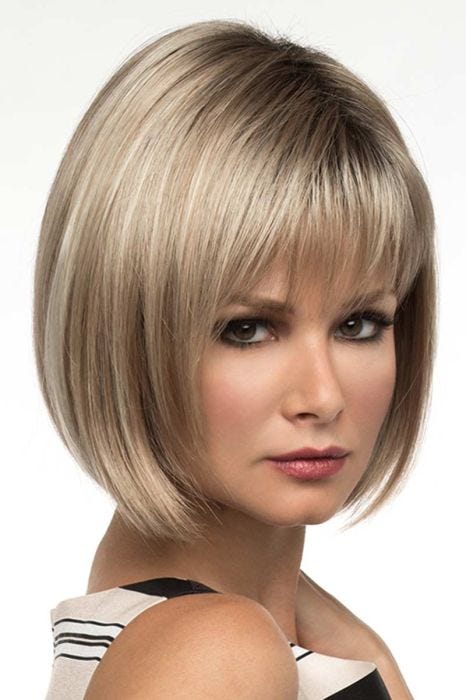 Woman in a chin length ash blonde bob wig with fringe bangs