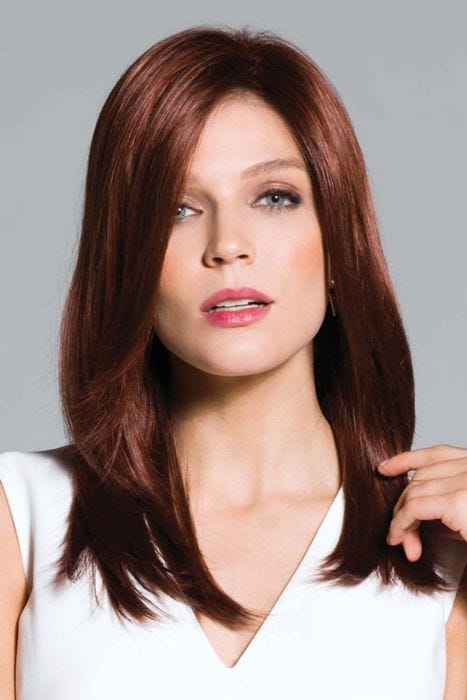 Woman in long straight dirty blonde wig with bangs and layers