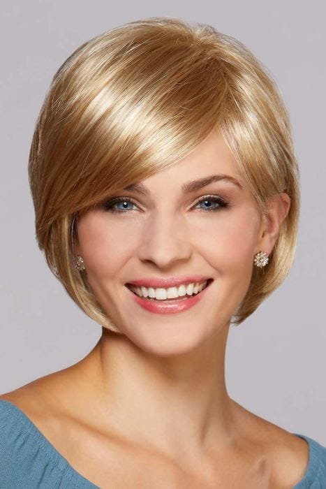 Woman in a chin length light gold blonde bob wig with long side bangs