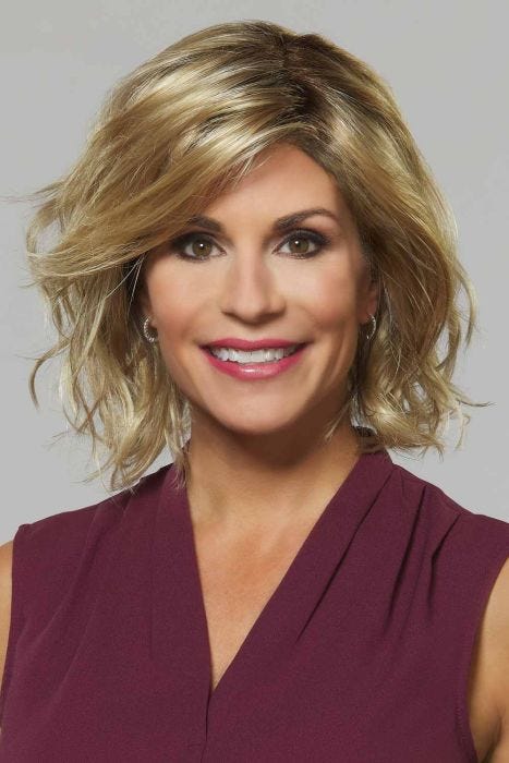 Woman in a shoulder length gold blonde curly bob wig with layers