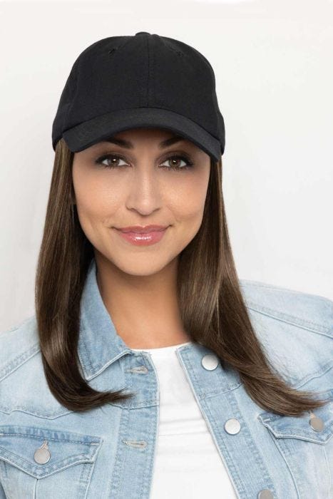 Woman in a solid black baseball cap with extra long deep auburn hair attached