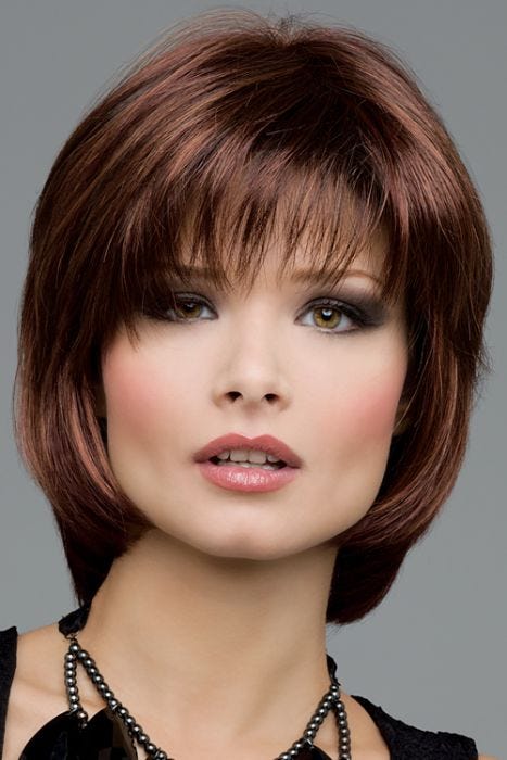 Woman in a short medium auburn bob wig with shaggy bangs and short face framing layers
