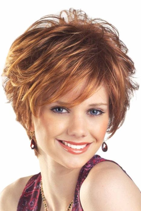 Woman in a tousled light red layered pixie wig with side bangs