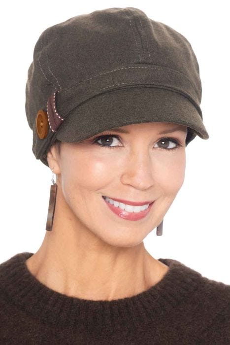 Woman in olive winter newsboy hat for cancer patients with button on the side