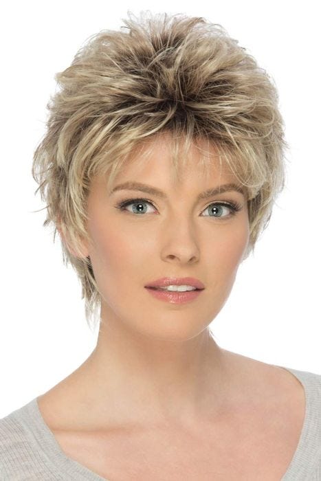 Woman in a long teased dark blonde pixie wig with fringe bangs