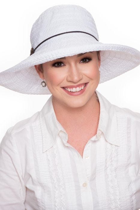 Woman in white wide brimmed ribbon braid sun hat