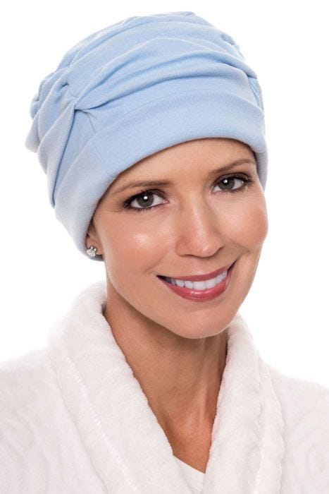Woman in light blue shirred cotton sleeping cap for cancer patients