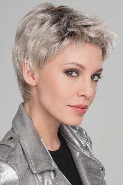 Woman in a classic short grey pixie wig with dark roots